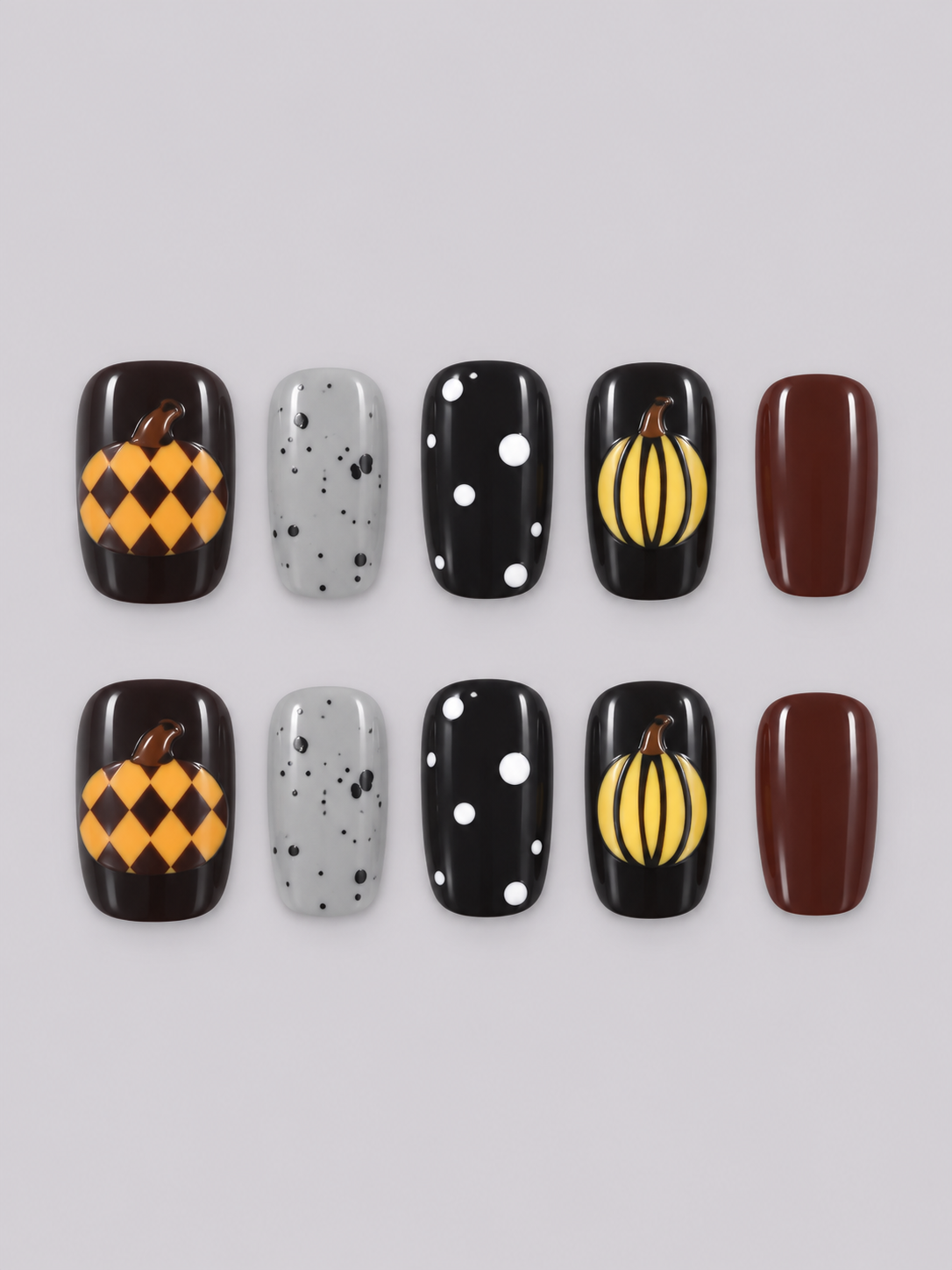 Close-up of hands with decorative black, orange, red, and gray nail art, wearing a black long-sleeve top against a light gray background.