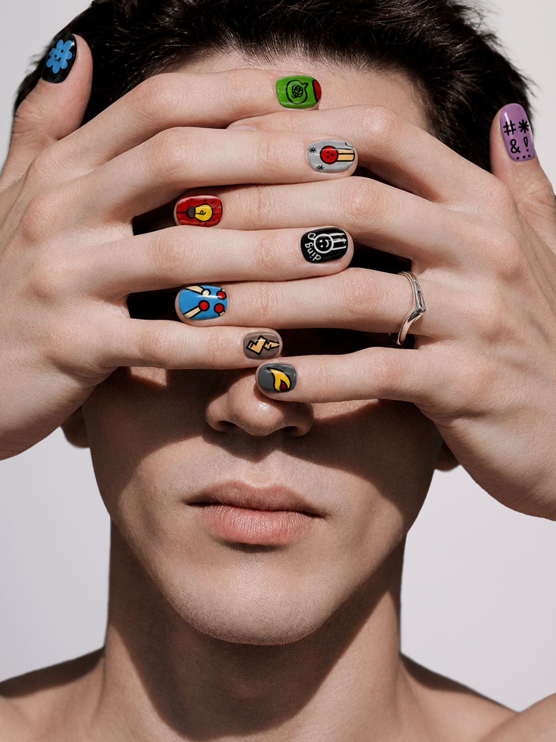 A set of ten false press-on nails with various colorful hand-painted doodle designs, arranged in two rows on a light gray background.