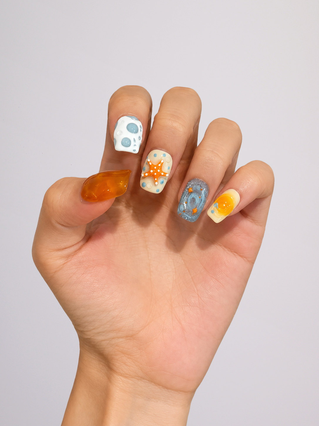 Close-up of blue and orange floral press-on nail details
