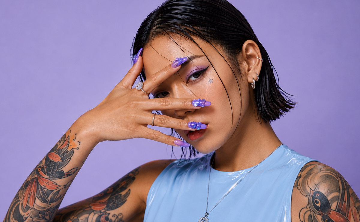 Person with tattoos and colorful makeup against a purple background1621243260e1af0c20-0