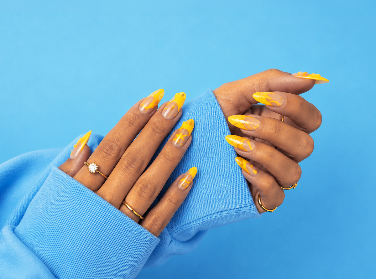 Hands with yellow nail polish wearing a blue sleeve against a blue background
